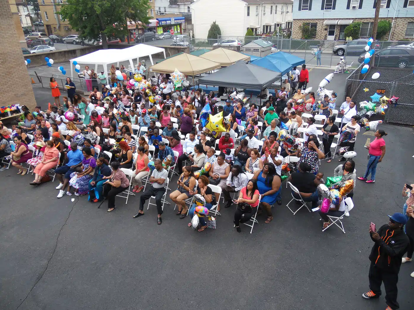Families and community members gathered outdoors with PDC100